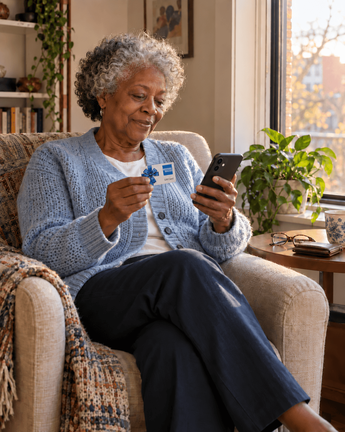 A woman holding an American Express gift card and her phone at home